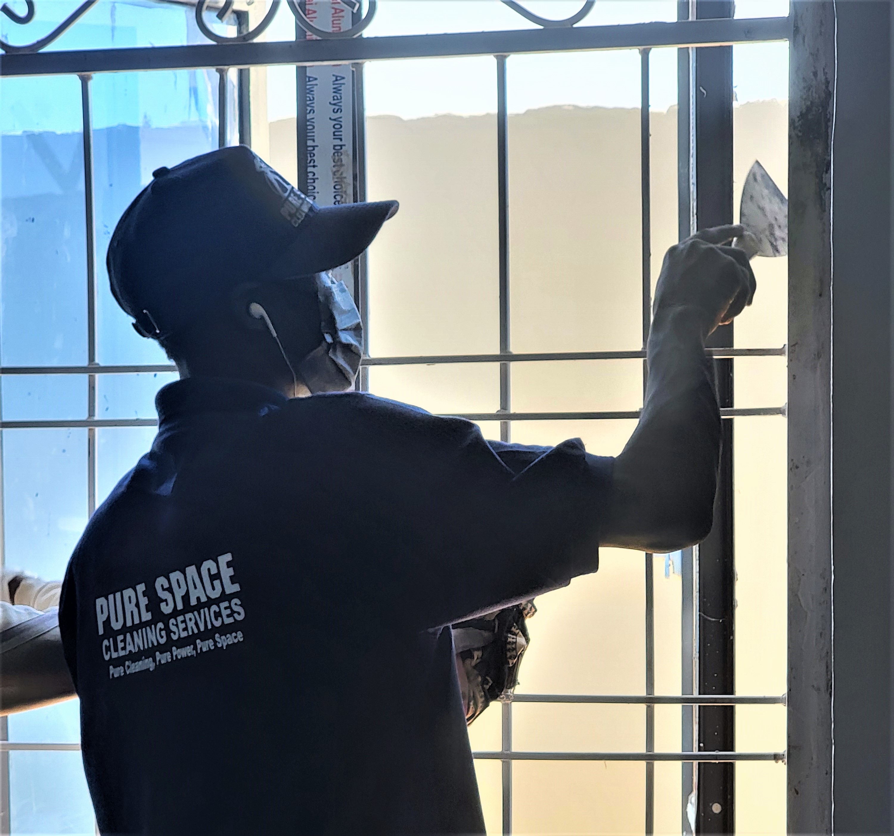 Worker using pressure washer on a roof